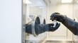 © 19.911a Digital - Person in black gloves handling a small vial with a red cap inside a clear laboratory glove box for sterile or hazardous material work.