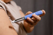 © Oleg - A horizontal close up of an young woman giving an injection to her shoulder