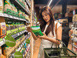 © Apichat - Woman choosing organic food for healthy lifestyle grocery shopping