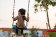 © geargodz - cheerful child girl playing on swing at playground