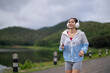 © Wasana - Woman running outdoors listening music with headphones