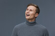 © SHOTPRIME STUDIO - Smiling man wearing gray knitted turtleneck sweater looking away isolated on dark gray background, happy cheerful male portrait, digital nomad, freelance communication concept