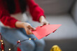 © Charlie's - Asian Woman giving red envelope for Lunar New Year celebrations. Hand hold red packet