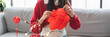 © Charlie's - Asian Woman decorated house for Chinese New Year Celebrations. putting traditional pendant to the Chinese Lunar New Year for good luck. Chinese word means blessing