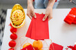 © Charlie's - Asian Woman giving red envelope for Lunar New Year celebrations. Hand hold red packet
