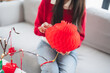 © Charlie's - Asian Woman decorated house for Chinese New Year Celebrations. putting traditional pendant to the Chinese Lunar New Year for good luck. Chinese word means blessing