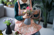 © Charlie's - Happy asian Woman arranging flowers caring for home greenery