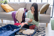 © Charlie's - Happy asian Woman packing suitcase for travel planning preparing vacation  in winter