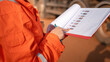 © Nattawit - Close-up at operation supervisor hand in action of checking on the document and certification during perform safety audit at construction working site. Industrial working scene.