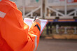 © Nattawit - A safety officer is checking on safety checklist to verify the risk of chemical transportation with Liquid nitrogen tank on background. Industrial working scene, close-up and selective focus.