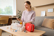 © Pixel-Shot - Young woman taking nasal drops from first aid kit at home
