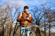 © Oscar - Young man cycling in urban park using smartphone