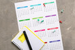 © Pixel-Shot - Calendar with notebook and pins on grunge grey background. Planning concept