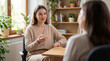 © Anastasiya - Female counselor gives counseling to client. Counseling session in sunlit office with plants and books, counseling support for world mental health day, self care coaching, calm mindset