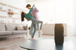 © Prostock-studio - Millennial Asian couple dancing to popular music at home, selective focus on portable wireless speaker on table, copy space. Young family moving to their favorite song, using modern device