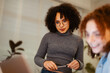 © Studio Marmellata - Two young women collaborate on a project, one focused on a laptop while the other holds a pen, suggesting teamwork and shared learning.