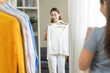 © Pormezz - Young asian women looking at mirror choose outfit before go out at home.