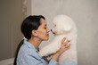 © ADDICTIVE STOCK - Woman cuddling her fluffy dog at home