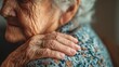 © Darnisha - Close-up of elderly woman's hand on shoulder, showcasing skin texture, and a wedding band