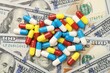© New Africa - Many different pills on dollar banknotes, top view