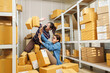 © Ekkasit A Siam - Asian adult women online business partners trying to control falling parcel box during order packing process inside home warehouse representing online shopping parcel box problem and teamwork effort