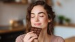 © Formoney - Woman is eating a chocolate bar and smiling. Scene is happy and relaxed