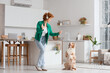 © Pixel-Shot - Redhead young woman with mobile phone and Australian Shepherd dog dancing in kitchen