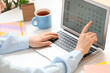 © Pixel-Shot - Female hands using laptop with calendar at table, closeup