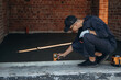 © standret - Checking if the level is right. Builder is working on construction site, unfinished building