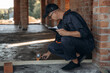 © standret - Checking if the level is right. Builder is working on construction site, unfinished building