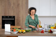 © Pixel-Shot - Mature woman cutting onion for salad in kitchen