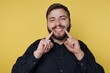© bodnarphoto - Joyful man showcasing brilliant smile against vibrant yellow backdrop during a lively moment of happiness and positivity