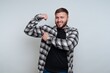 © bodnarphoto - Confident young man showing off his strength in a modern studio during a joyful moment