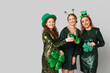 © Pixel-Shot - Beautiful women with beer and clovers on light background. St. Patrick's Day celebration