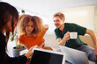 © Johnér - Multiracial male and female business employees looking in smart phone held by coworker at office
