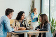© Suteren Studio - Diverse coworkers collaborating during office coffee break discussion