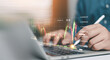 © ภัทรชัย รัตนชัยวงค์ - Business professional analyzing stock market data on laptop with stylus pen, financial chart overlay, forex trading strategy, investment analytics, fintech technology and economic growth concept.