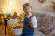 © Tomsickova - Sweet preschool boy in studio, playing with, egg for Easter and eating chocolate, child on Easter holiday