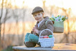 © Tomsickova - Beautiful stylish toddler child, boy, playing with Easter decoration in the park, springtime