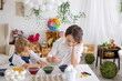 © Tomsickova - Happy childen, siblings, coloring eggs for Easter at home, sunny room