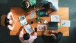 © InfiniteFlow - Top view of diverse business people working together to analyze chart. Top down aerial view of creative team looking at stock market report and discussing about financial investment. Convocation.