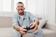 © SHOTPRIME STUDIO - Happy man playing video games at home with excitement, showcasing modern lifestyle and entertainment trends, perfect for gaming and leisure themes.