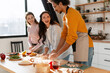 © Maria Vitkovska - Friends preparing food together in kitchen, laughing and enjoying cooking at home