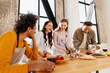 © Maria Vitkovska - Diverse friends preparing pizza in modern kitchen, laughing and enjoying cooking