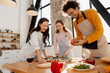 © Maria Vitkovska - Friends enjoying cooking pizza together at a kitchen party, sharing happy moment