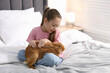 © New Africa - Girl with cute bunny on bed at home. Space for text