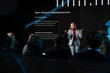 © DC Studio - Motivational business presentation at international summit with diverse audience members, networking event in conference hall. Female CEO presenter speaks to listeners about development.