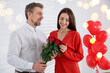 © New Africa - Happy couple celebrating Valentine's day in room with heart-shaped balloons. Bokeh lights