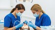 © tafazzal - Two dental professionals performing a procedure on a patient's teeth.