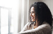 © BuyoutReese09/peopleimages.com - Reflection, relax and woman with smile, home and nostalgia for memory, daydreaming or remember. Apartment, window or person in living room for break, choice or thinking with contemplation or decision